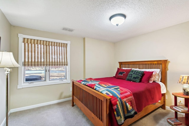 carpeted bedroom with baseboards, visible vents, and a textured ceiling