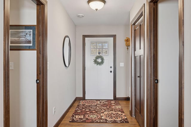 doorway to outside featuring light wood finished floors and baseboards