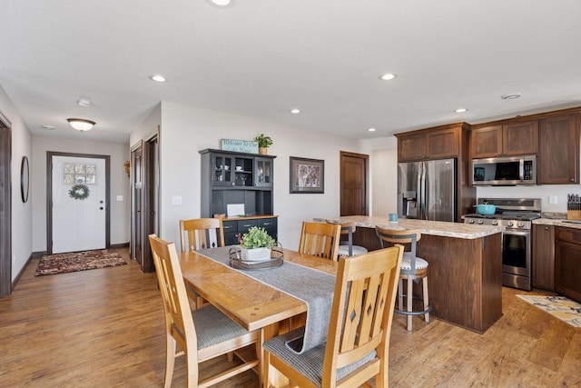 dining room with recessed lighting and light wood-style floors