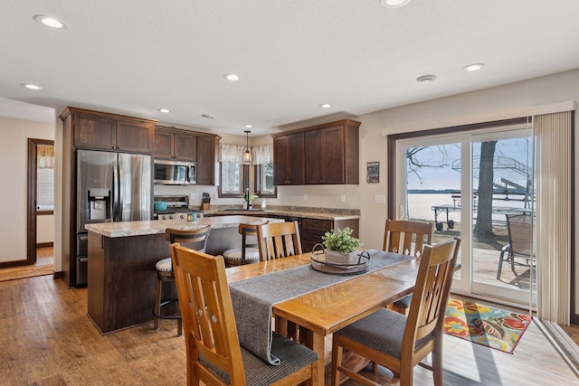 dining space featuring recessed lighting, light wood-type flooring, and baseboards