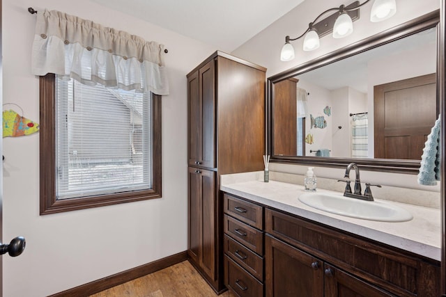 full bathroom featuring vanity, baseboards, and wood finished floors