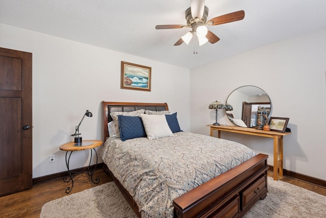 bedroom with ceiling fan, baseboards, and wood finished floors