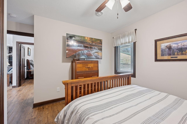 bedroom with ceiling fan, baseboards, and wood finished floors