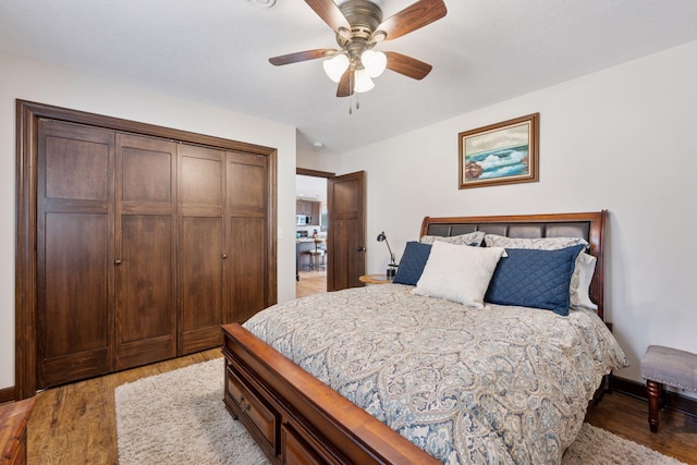 bedroom with light wood-style flooring, a ceiling fan, a closet, and baseboards