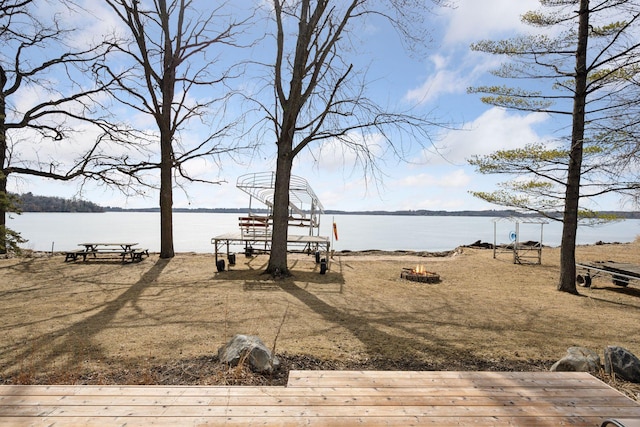 view of yard featuring a water view and an outdoor fire pit