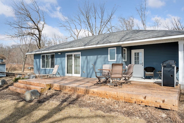 back of property featuring a wooden deck and roof with shingles