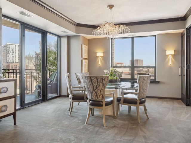 dining room featuring a notable chandelier, ornamental molding, and carpet