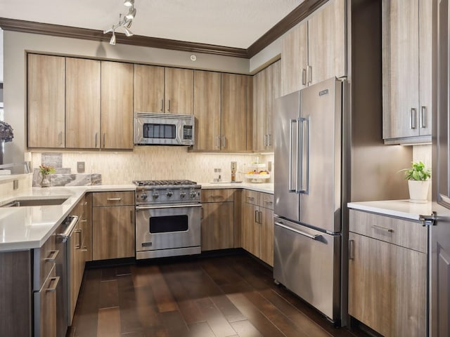 kitchen featuring high end appliances, dark wood-style flooring, ornamental molding, light countertops, and tasteful backsplash