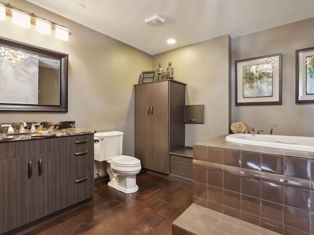 full bath with vanity, toilet, wood finished floors, and a bath