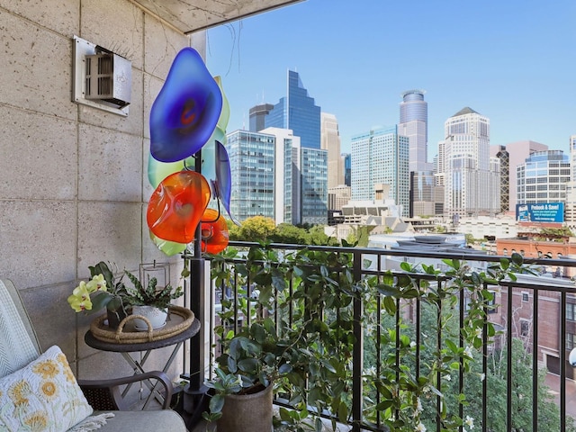 balcony featuring a city view and a wall mounted air conditioner