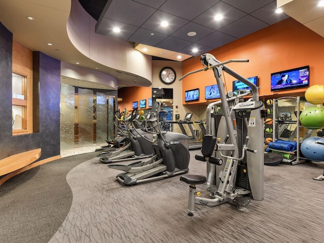 workout area featuring carpet flooring, recessed lighting, and a towering ceiling