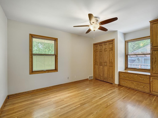 5109 Richmond Dr, Edina, MN 55436 - unfurnished bedroom featuring light wood-type flooring, multiple windows, a closet, and ceiling fan