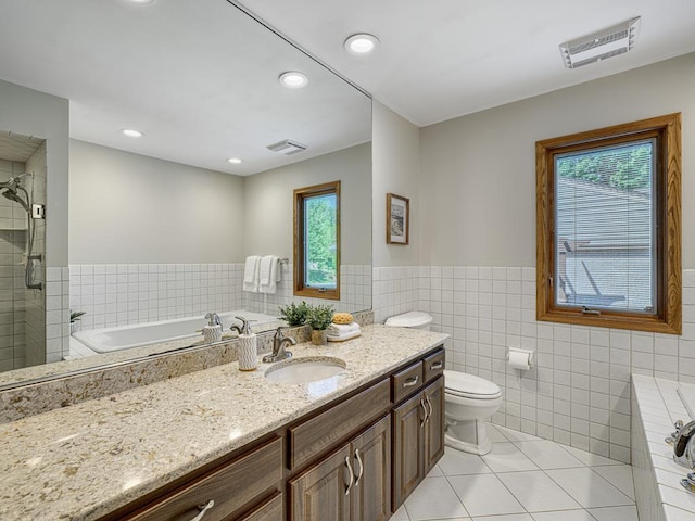 5109 Richmond Dr, Edina, MN 55436 - bathroom with tile patterned flooring, tile walls, vanity, a garden tub, and wainscoting