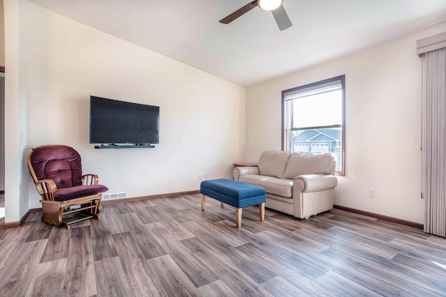 living area featuring ceiling fan, visible vents, baseboards, and wood finished floors