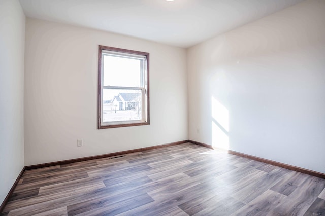 empty room featuring baseboards and wood finished floors