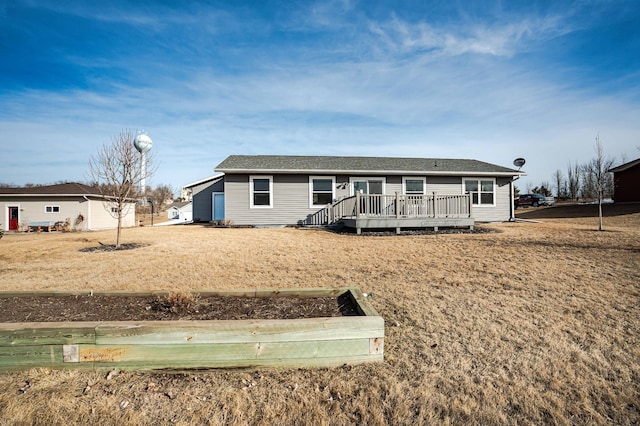 rear view of house with a wooden deck and roof with shingles