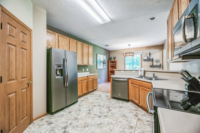 kitchen with light countertops, light tile patterned floors, a peninsula, stainless steel appliances, and a sink