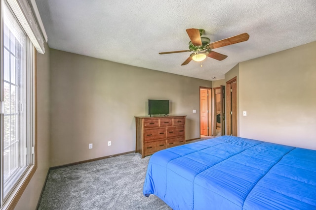 carpeted bedroom featuring multiple windows, a ceiling fan, baseboards, and a textured ceiling