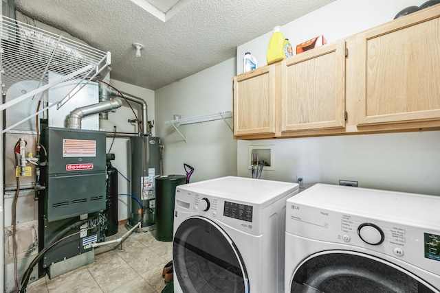 laundry area featuring washer and dryer, a textured ceiling, water heater, cabinet space, and light tile patterned floors