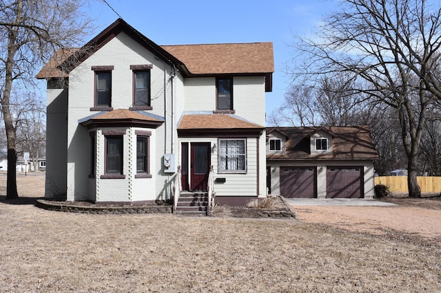 view of front of house with entry steps, a garage, brick siding, and driveway