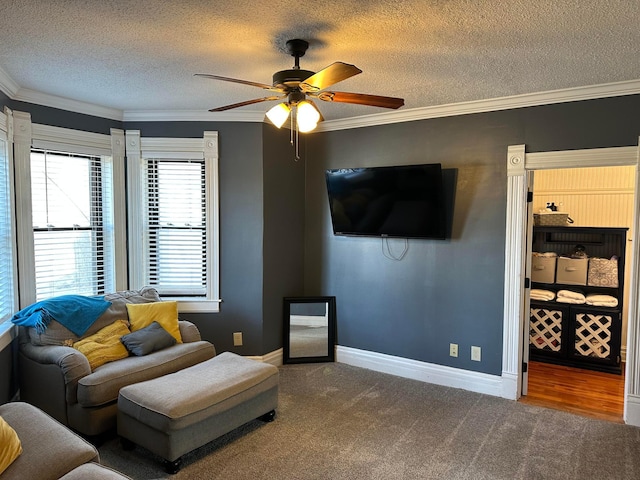 carpeted living area featuring a textured ceiling, crown molding, baseboards, and ceiling fan