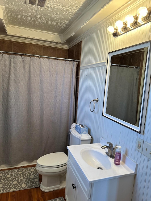 full bath featuring toilet, an ornate ceiling, wood finished floors, crown molding, and vanity