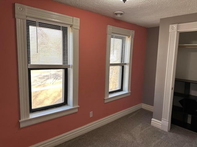 unfurnished bedroom with carpet, baseboards, a closet, and a textured ceiling