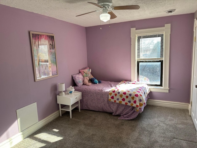 carpeted bedroom featuring baseboards, a textured ceiling, and a ceiling fan