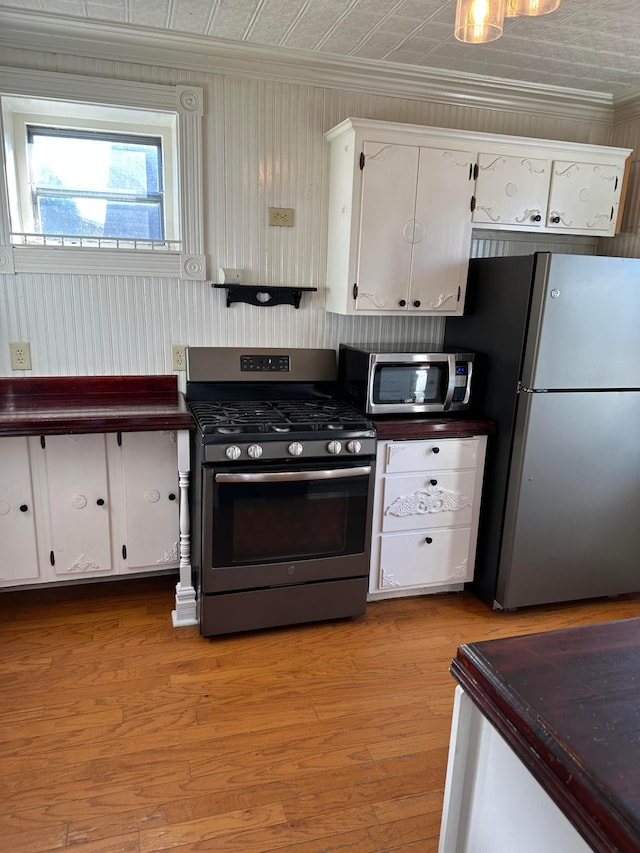 kitchen with crown molding, white cabinets, an ornate ceiling, and appliances with stainless steel finishes