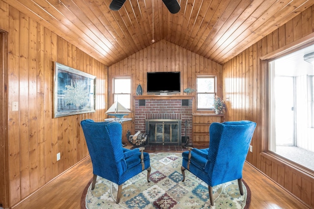 living area with plenty of natural light, lofted ceiling, and wood finished floors