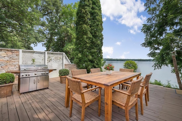 deck featuring outdoor dining space and a water view