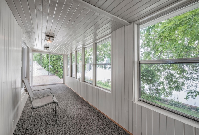 sunroom / solarium featuring a healthy amount of sunlight and wooden ceiling