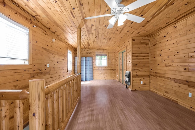 bonus room with ceiling fan, wood walls, wooden ceiling, wood finished floors, and heating unit