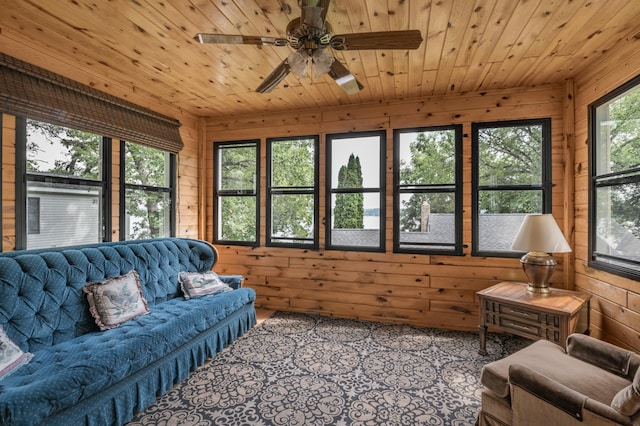 living room featuring wood walls, wooden ceiling, and a ceiling fan