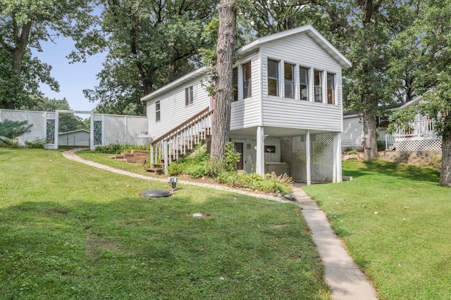 exterior space featuring stairs, a lawn, and fence