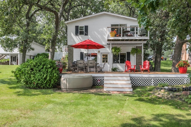 back of house featuring a yard, a deck, and a balcony