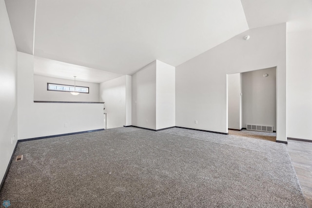 unfurnished room featuring vaulted ceiling, baseboards, visible vents, and carpet floors