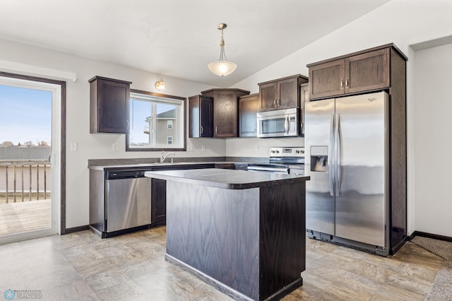 kitchen with a center island, dark brown cabinetry, decorative light fixtures, vaulted ceiling, and appliances with stainless steel finishes