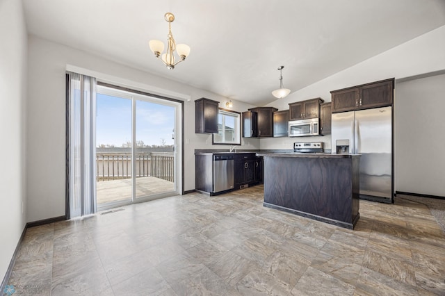 kitchen featuring dark brown cabinetry, vaulted ceiling, appliances with stainless steel finishes, an inviting chandelier, and hanging light fixtures