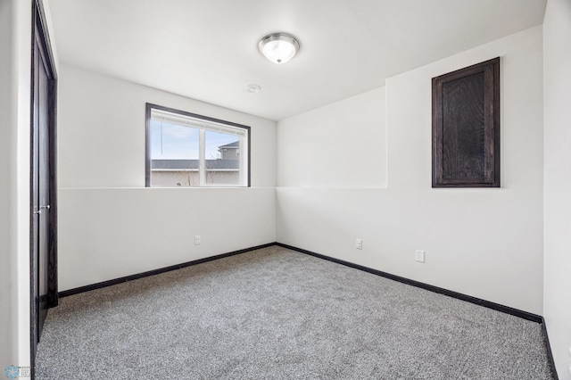 unfurnished room with baseboards and carpet floors