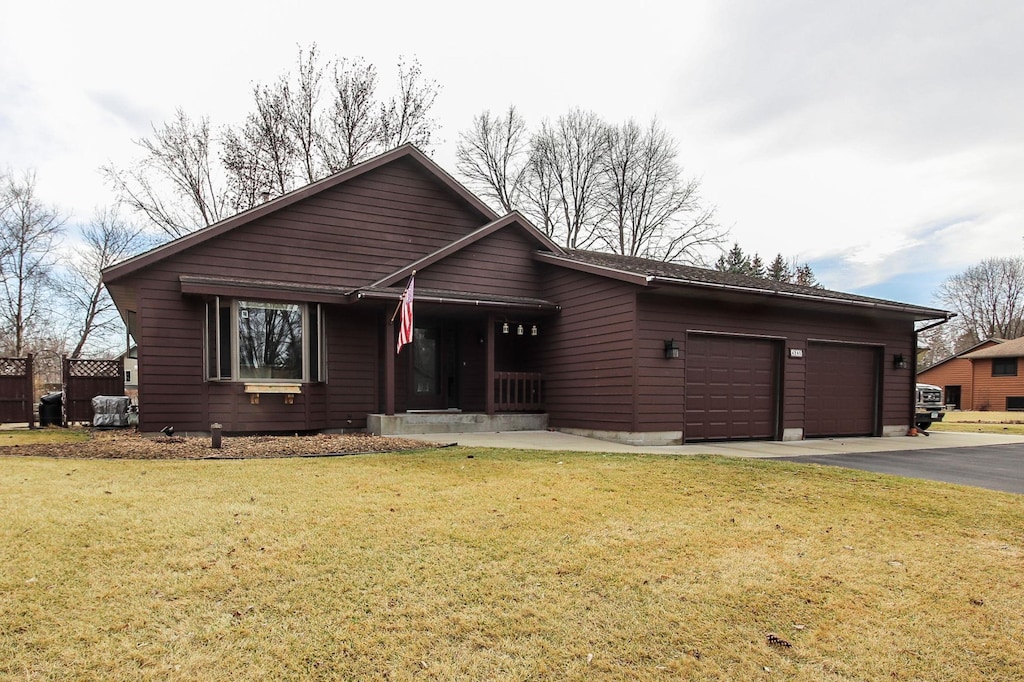 view of front facade with driveway, a front yard, and a garage