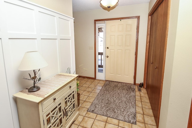 entrance foyer with light tile patterned floors and baseboards