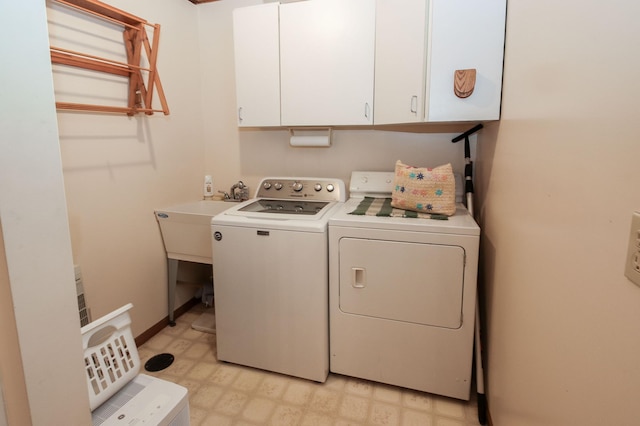 washroom with cabinet space, light floors, and washer and clothes dryer