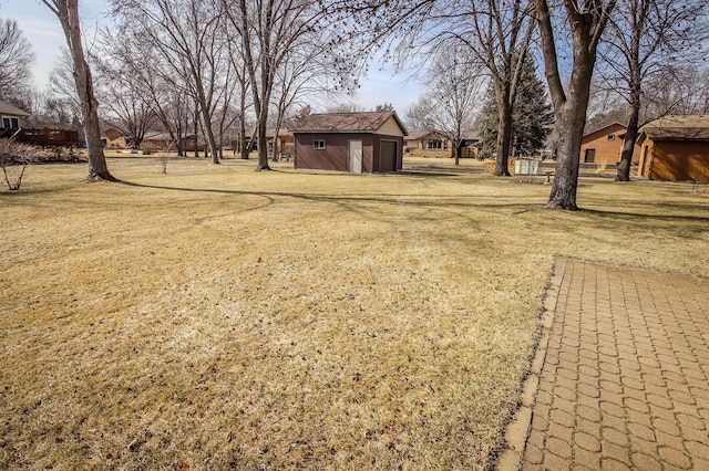 view of yard featuring a garage and an outdoor structure