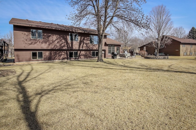 back of property featuring a patio and a lawn