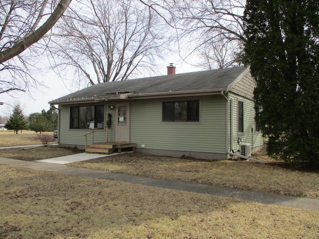 view of front of house with central air condition unit and a chimney