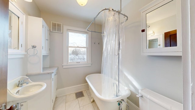 full bathroom featuring a sink, visible vents, a soaking tub, and toilet