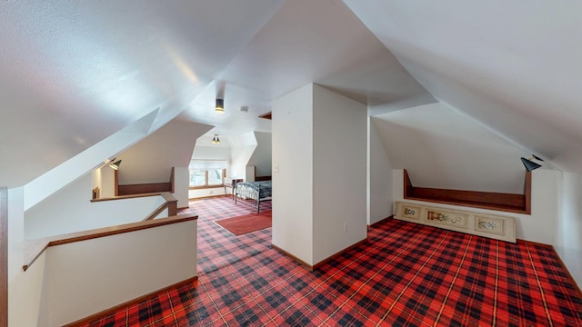 additional living space featuring carpet floors and vaulted ceiling