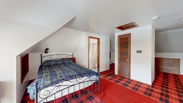 carpeted bedroom with attic access and vaulted ceiling