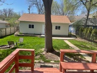 back of house with a yard, an outbuilding, and a fenced backyard